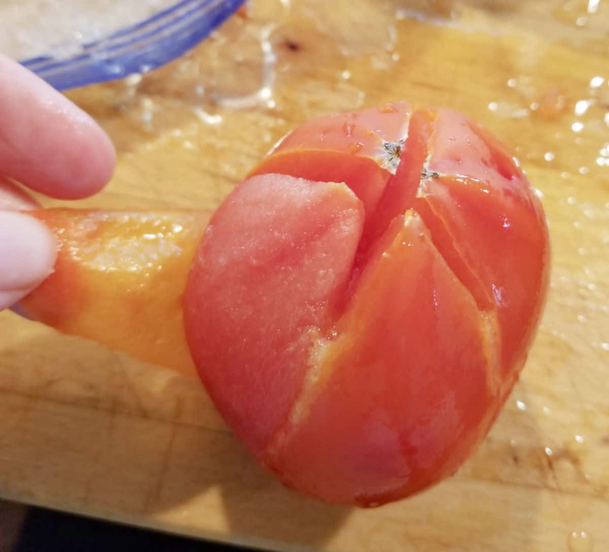 close up of easy peeling of tomato skin from frozen tomato