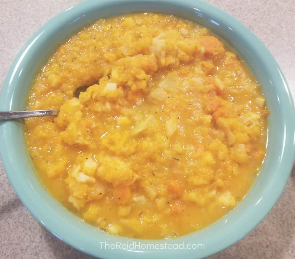 a large serving bowl full of a finished recipe of root veggie mash with butternut squash