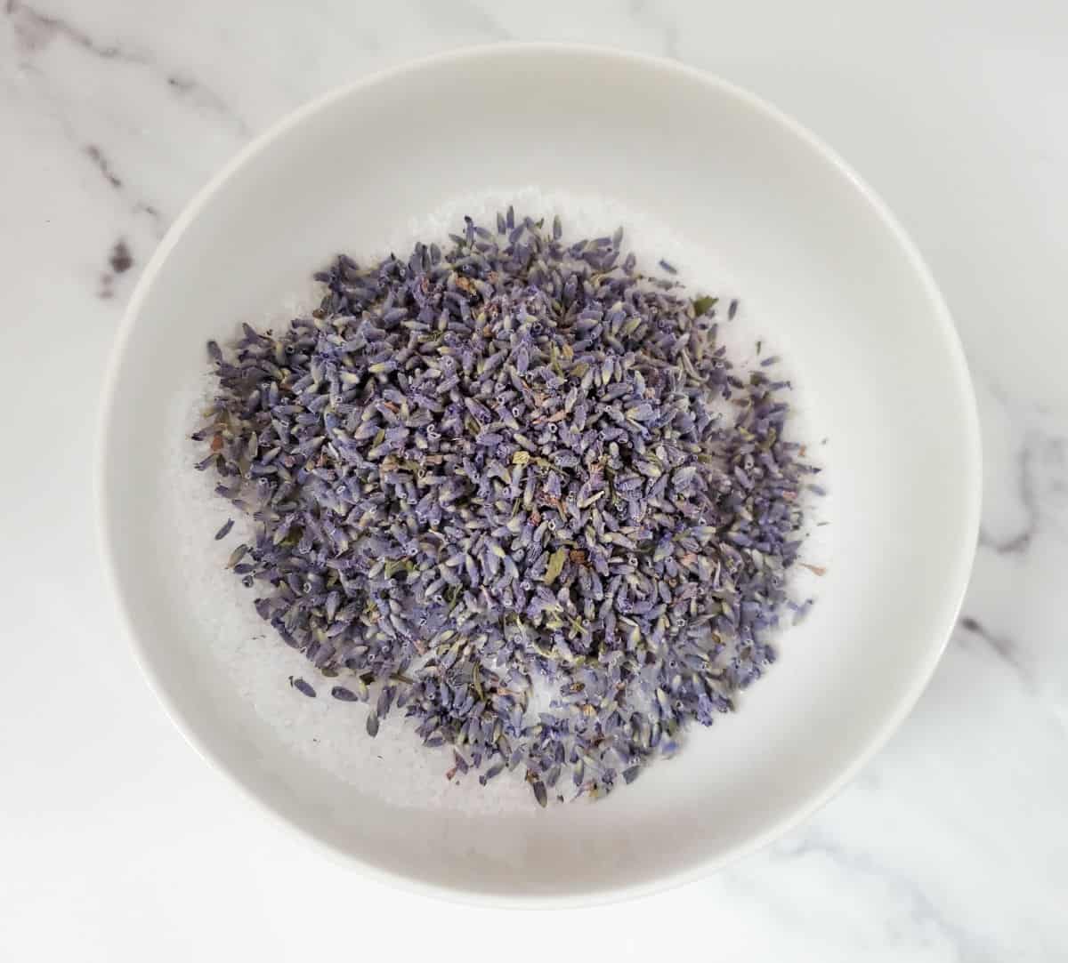 a bowl with epsom salts and lavender buds in it