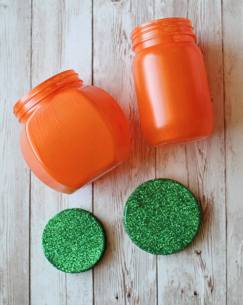 painted orange jars and green lids with green glitter added to lids