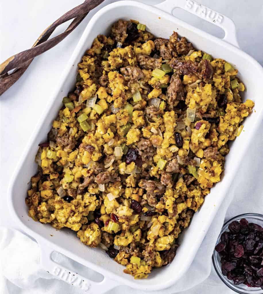 a white baking dish full of sausage cranberry stove top stuffing