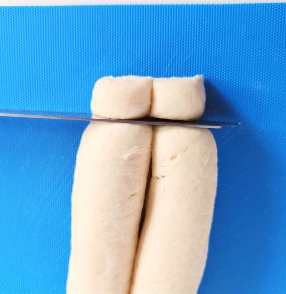 slicing rolled dough into ½" slices