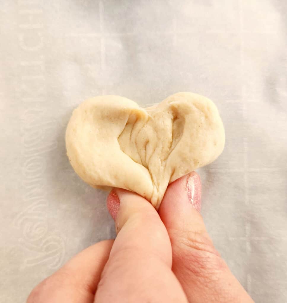 shaping the dough slices into hearts by pinching the bottom to a point