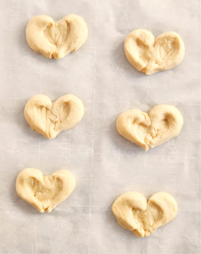 showing a cookie sheet full of heart shaped crescent roll pieces