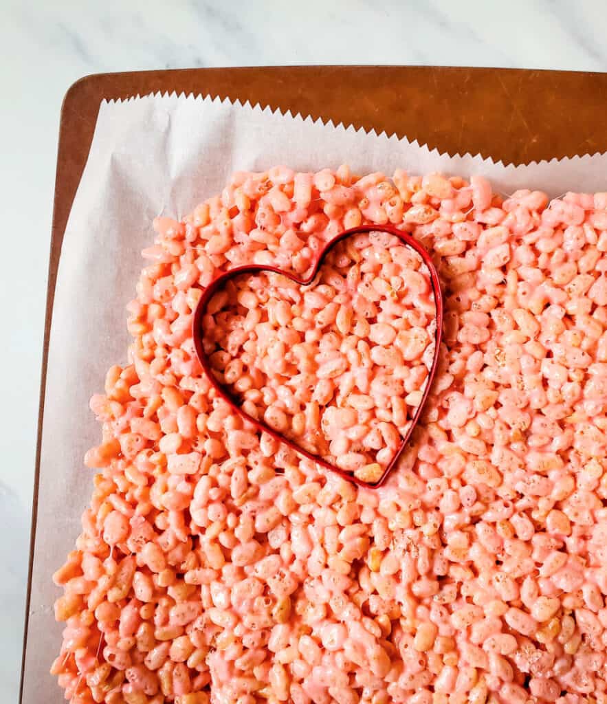 using a heart shaped cookie cutter, and cutting out the pink rice krispie treats
