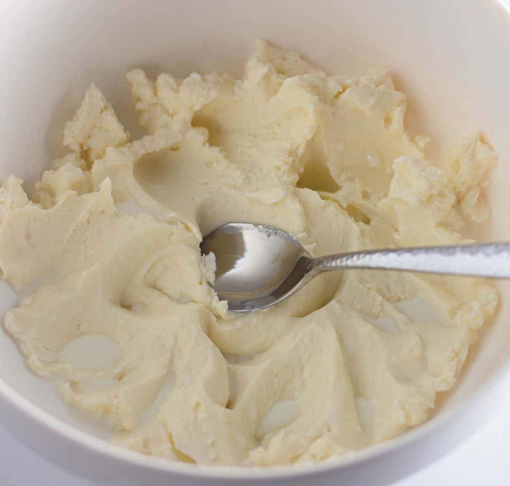 butter mashed in a bowl with pools of buttermilk