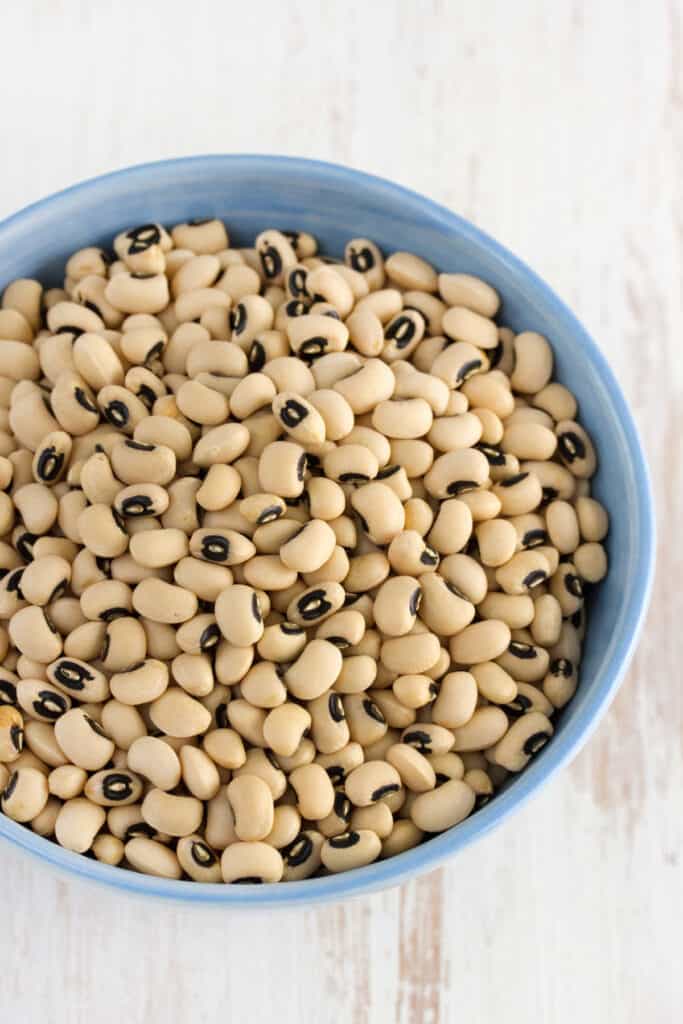 a blue bowl full of dried black eyed peas