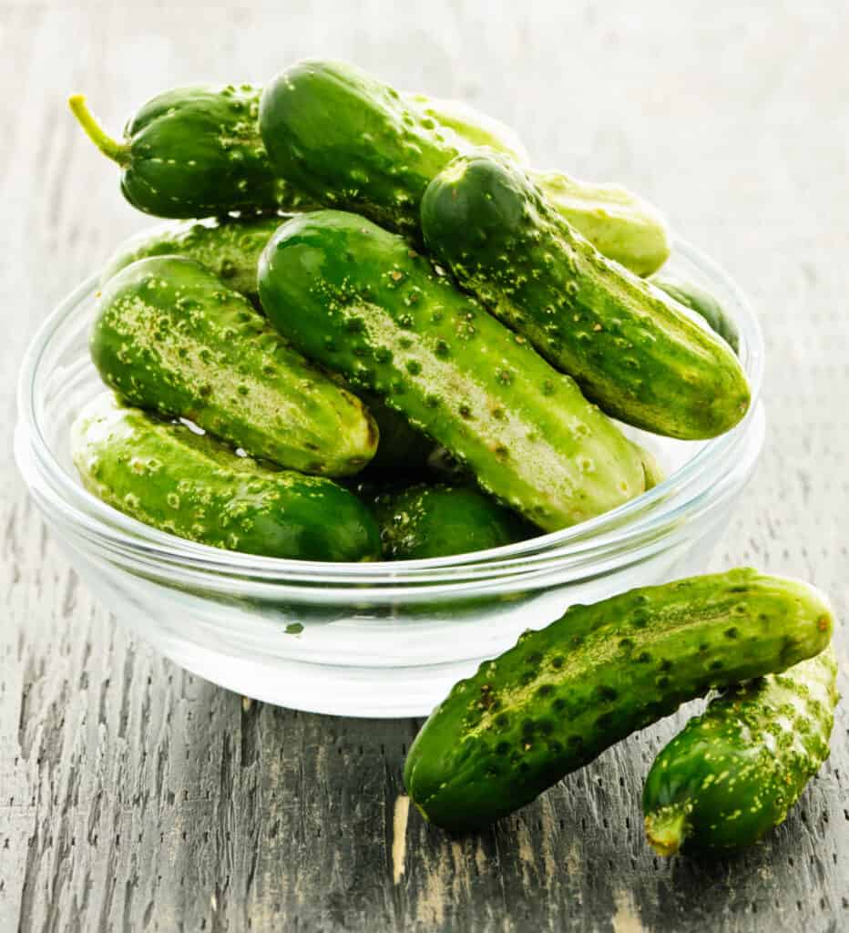 a large glass bowl full of pickling cucumbers